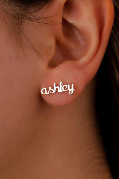 Earring with 'ashley' text worn on an ear