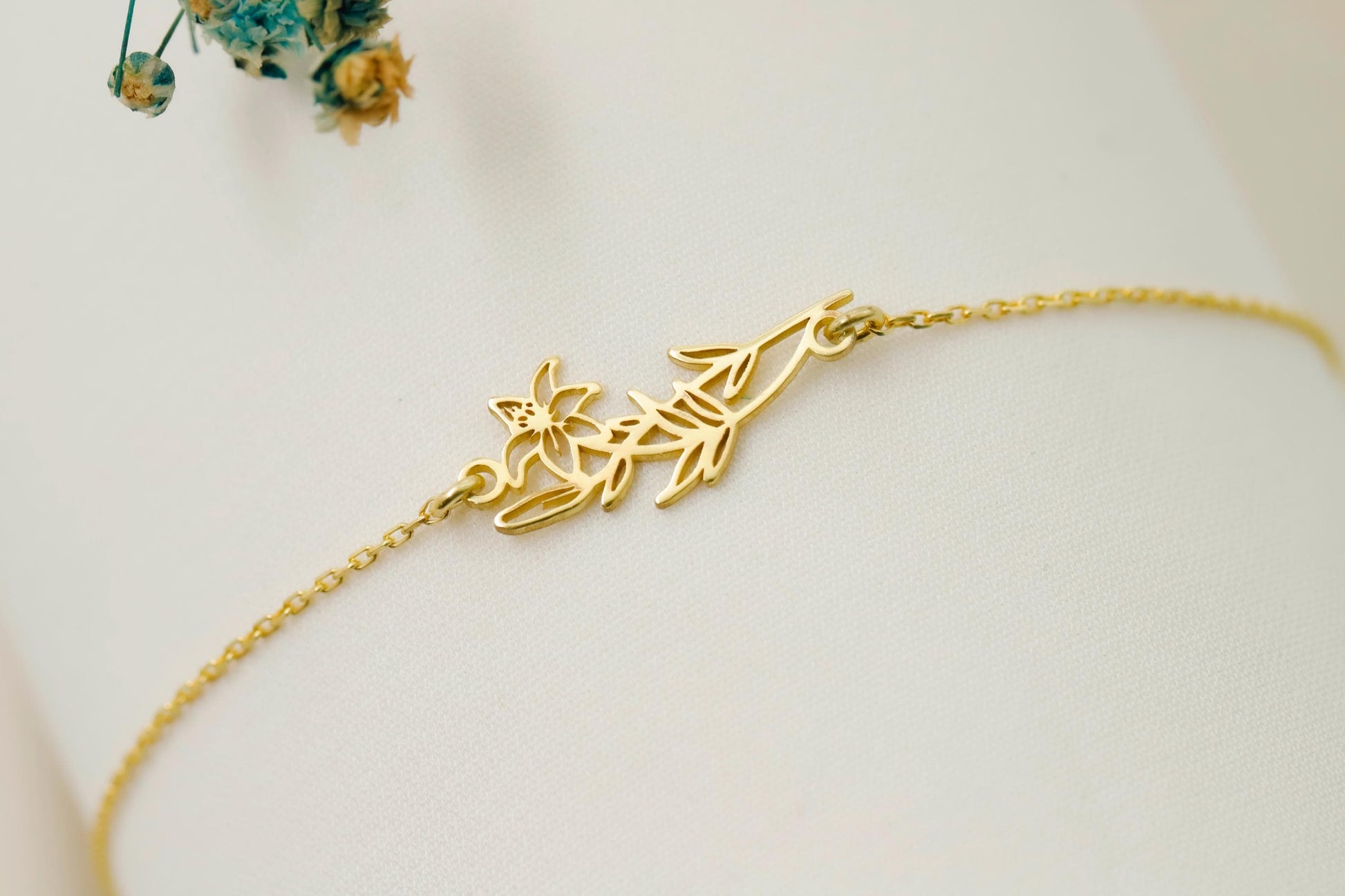 Gold bracelet with leaf design on a white surface