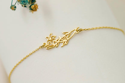 Gold bracelet with leaf design on a white surface