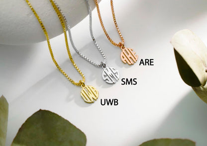 A close-up image of 3 monogram necklaces with a tiny initial pendant on a box chain