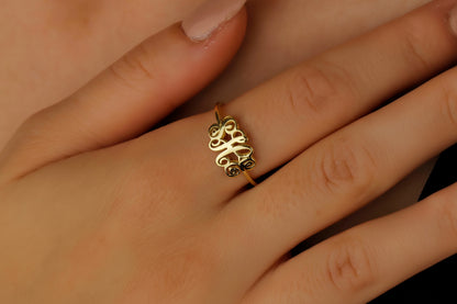 Gold ring with intricate design on a finger