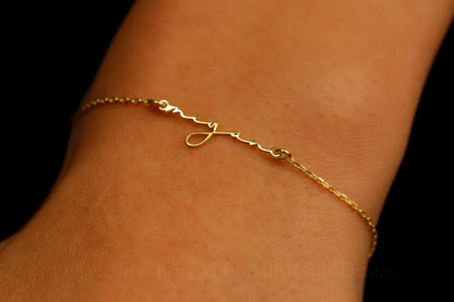 gold necklace on a light gray background with pink flowers in the corner