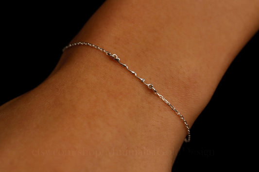 Silver necklace on a light gray background with pink flowers in the corner