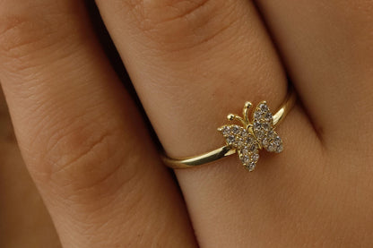 Gold butterfly ring on a person's finger