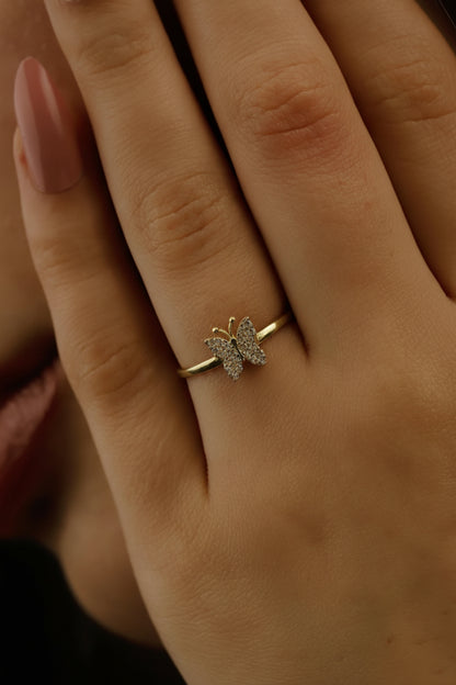 Gold butterfly ring Gold butterfly ring on a person's finger with a warm backgroundon a person's finger with a blurred background