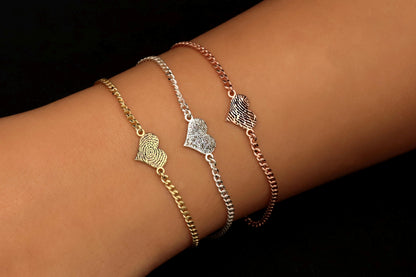 gold silver and rose gold bracelets with fingerprints engraving on a person's wrist.