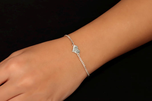 A sterling silver bracelet with a fingerprint engraving on a person's wrist.