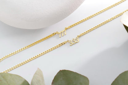 A close-up image of two sterling silver necklaces with the number 777 and 333 in a small, elegant font.