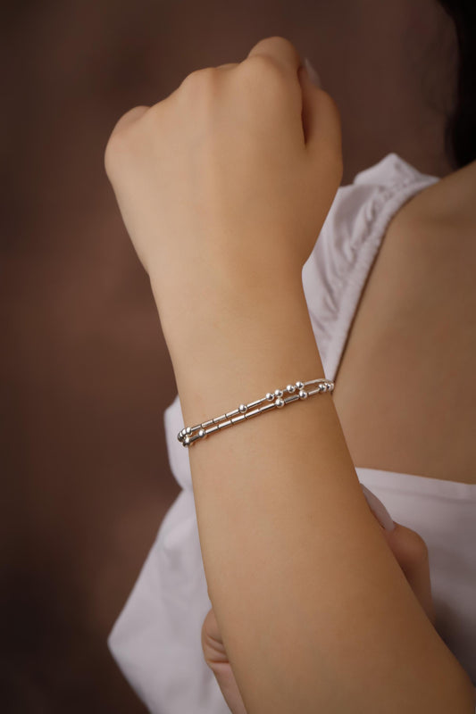 925 Sterling Silver Morse Code Bracelet with two strands hidden message, displayed on a white background next to a small green plant.