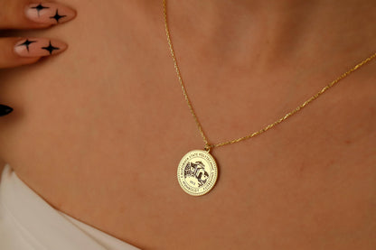 Gold necklace with a round pendant on a person's neck