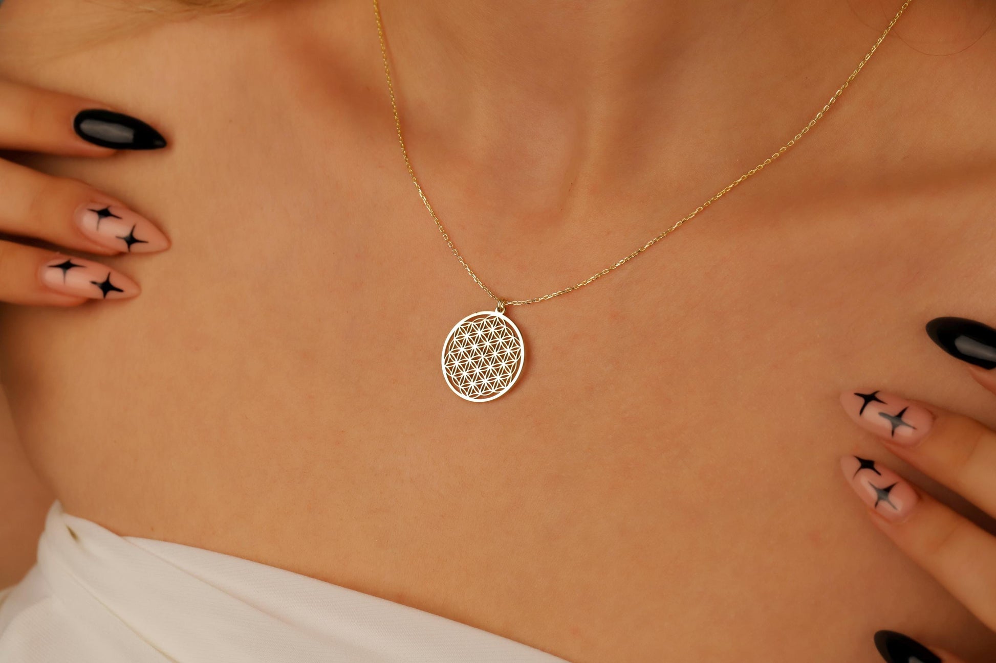 Gold necklace with a circular pendant on a person's neck