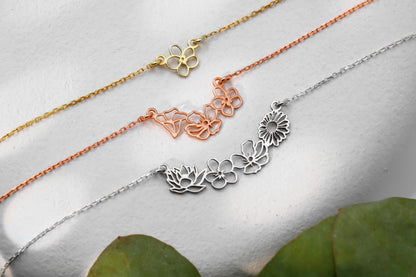 3 choker necklaces with gold interlocking flower charms.