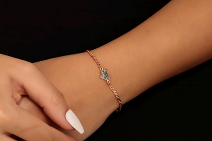 A rose gold bracelet with a fingerprint engraving on a person's wrist.