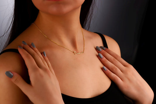 A gold name necklace with the name 'Cessica' displayed on a model.