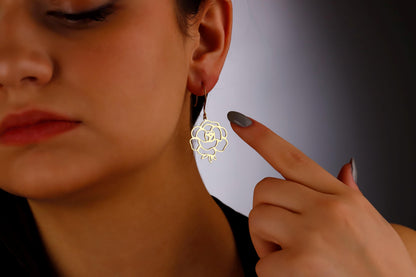 A woman showcasing a silver floral dangle earring.