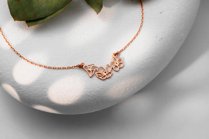 a choker necklace with gold interlocking flower charms.