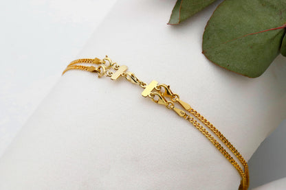 A close-up image of a layered gold necklace.