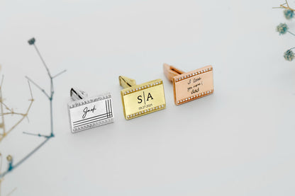 A set of personalized cufflinks with actual handwriting engraved on them, displayed in silver and gold tones.