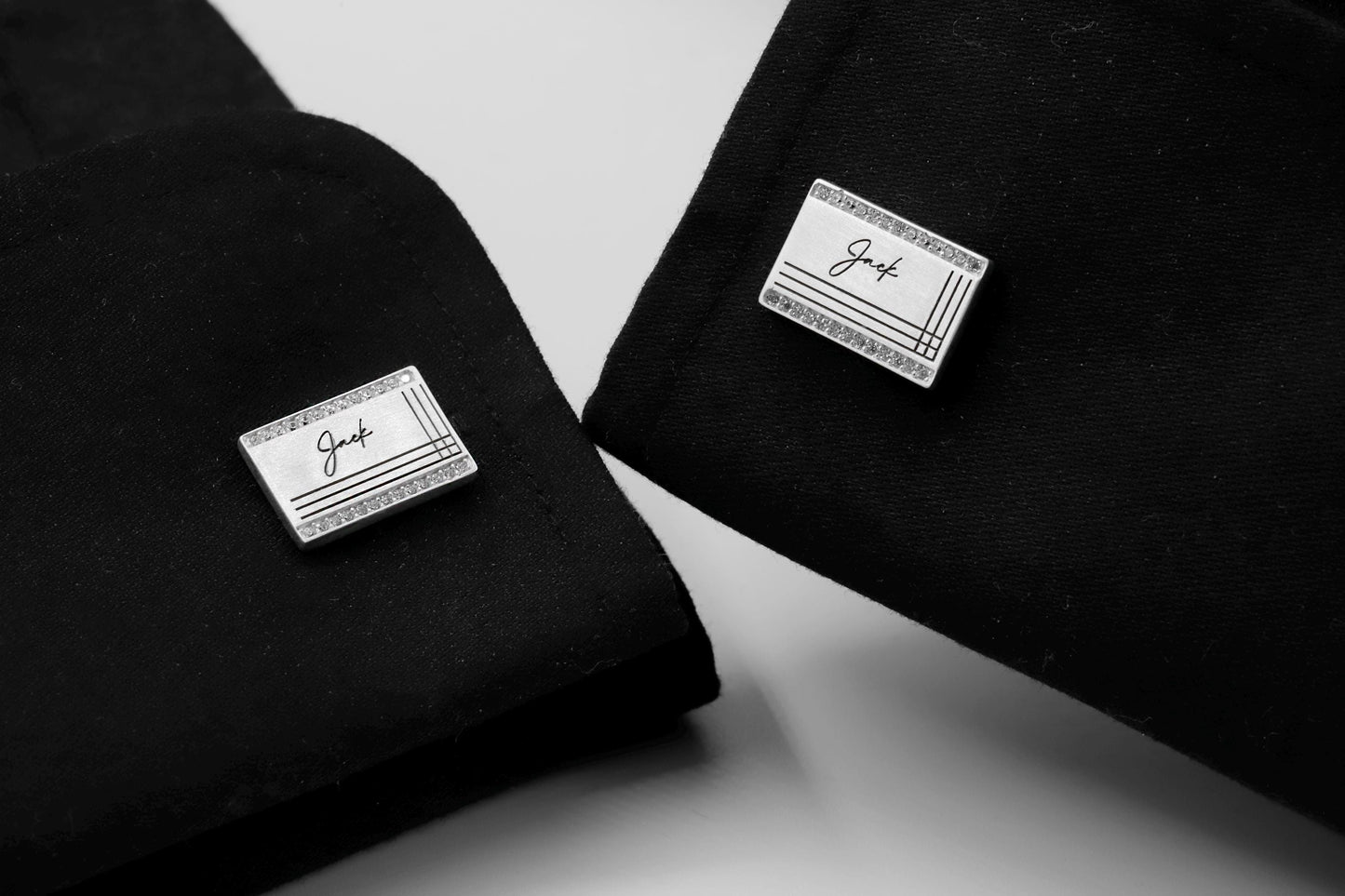 Two black shirts with 'Jack' branded cufflnks on a white background