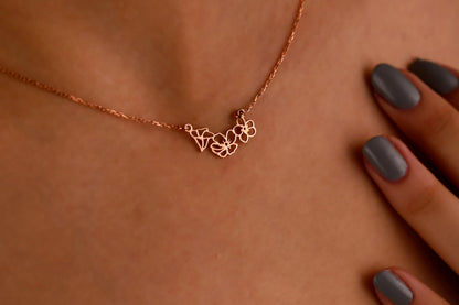 A woman wearing a choker necklace with gold interlocking flower charms.