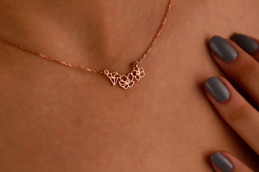 A woman wearing a choker necklace with gold interlocking flower charms.