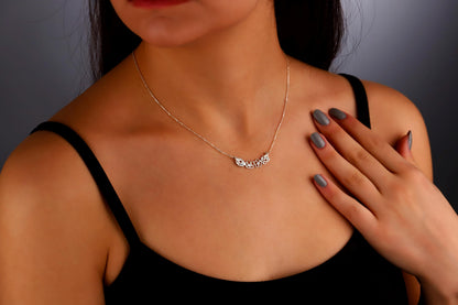 A woman wearing a choker necklace with gold interlocking flower charms.