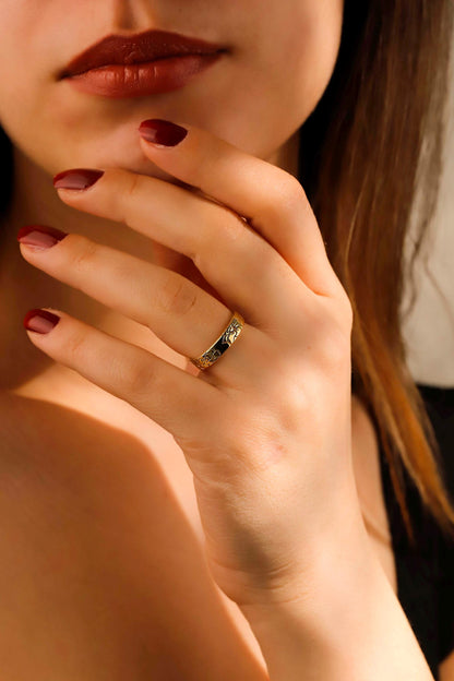 Close-up of a hand with a gold ring, focusing on the jewelry.