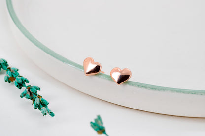 A close-up image of a rose gold stud bubble  heart-shaped earring.