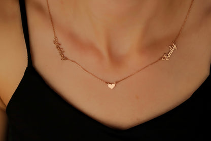 Rose gold necklace with heart pendant on a person wearing a black top.