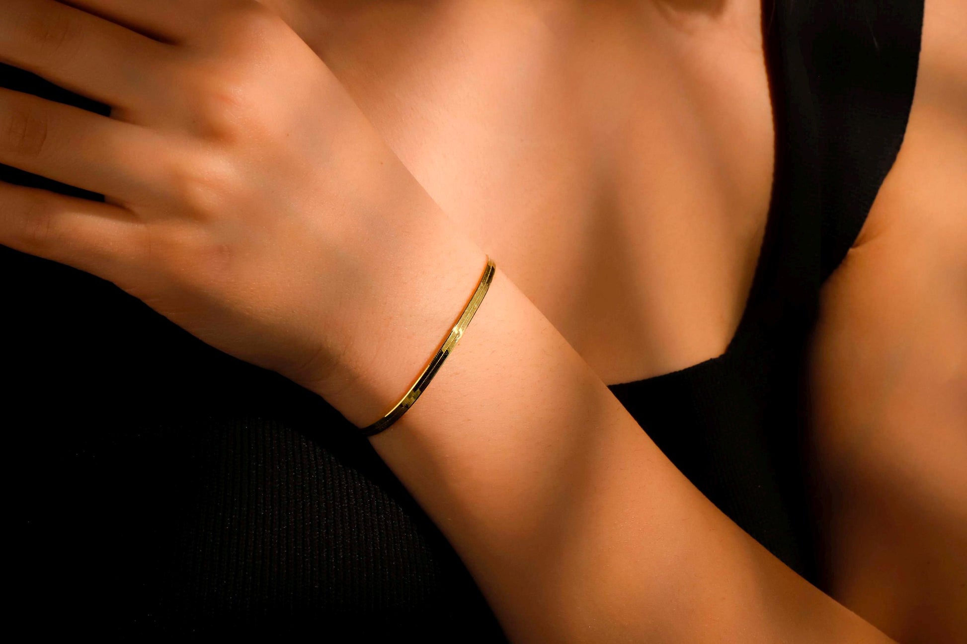 Gold bracelet on a wrist with a blurred background
