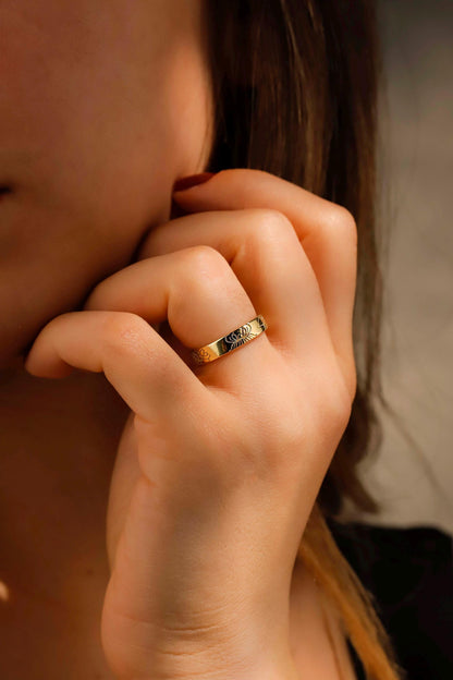 Close-up of a hand with a gold ring on a blurred background