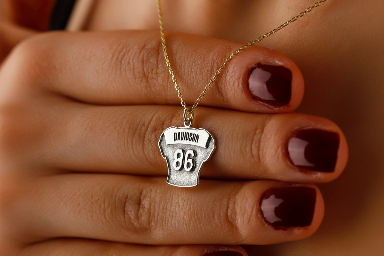 Necklace with a pendant on a hand with dark nail polish