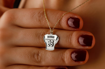 Necklace with a pendant on a hand with dark nail polish