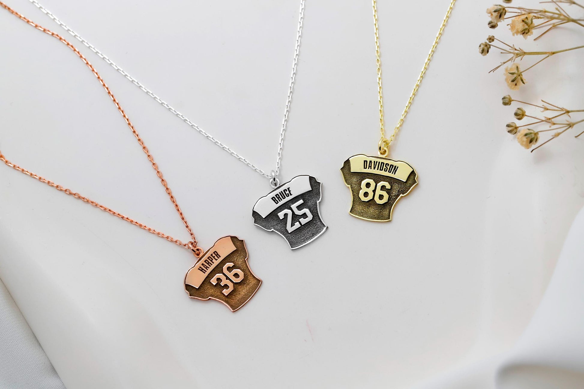 Three necklaces with different colored pendants on a white background