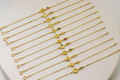 Gold flower necklaces and bracelets  with various charms on a white heart-shaped stand