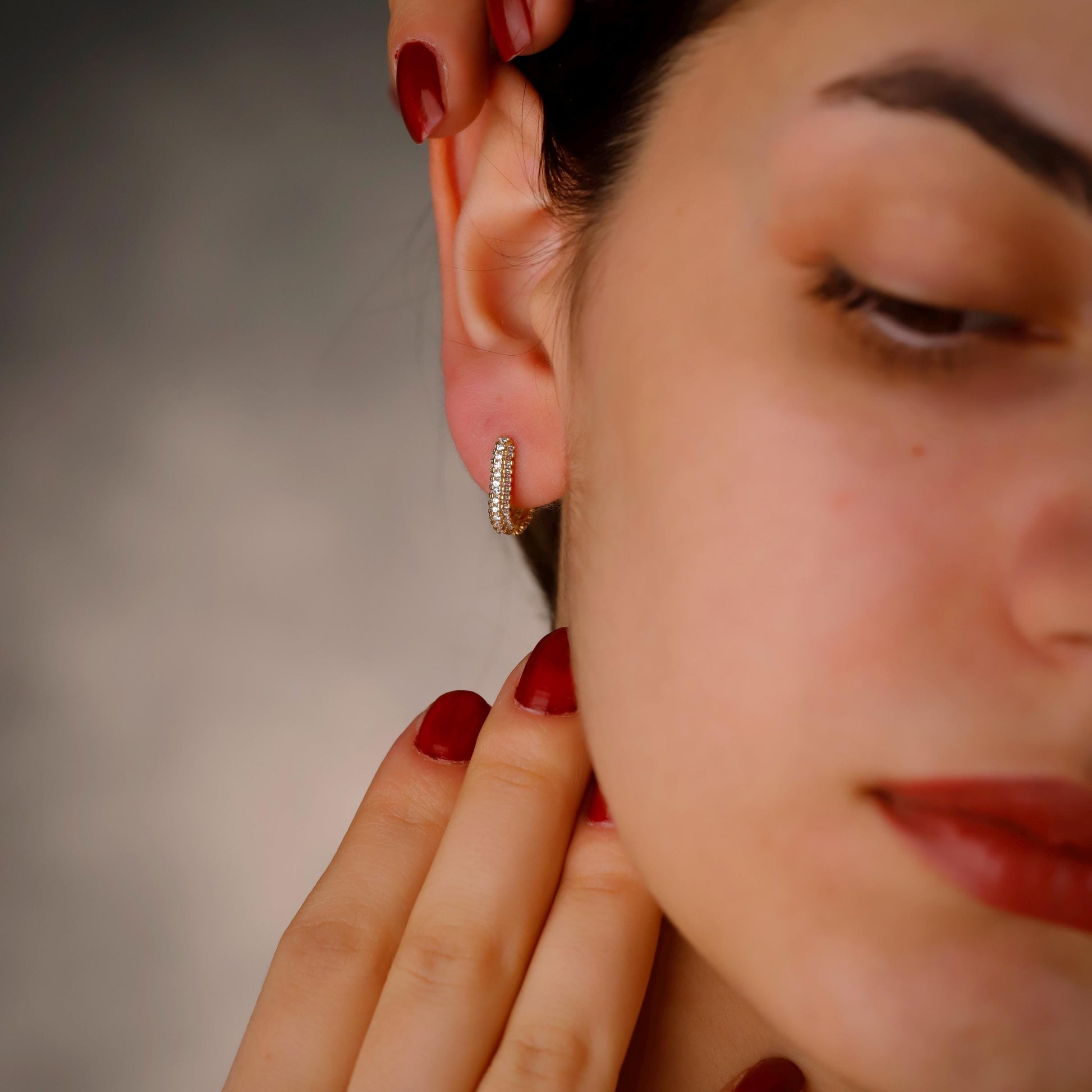 Close-up of a woman wearing a diamond earring with a blurred background