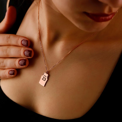Necklace with a pendant worn by a person, close-up on skin