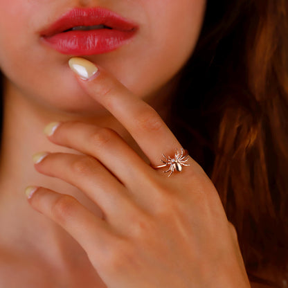 Close-up of a hand with a unique ring, near lips and hair.