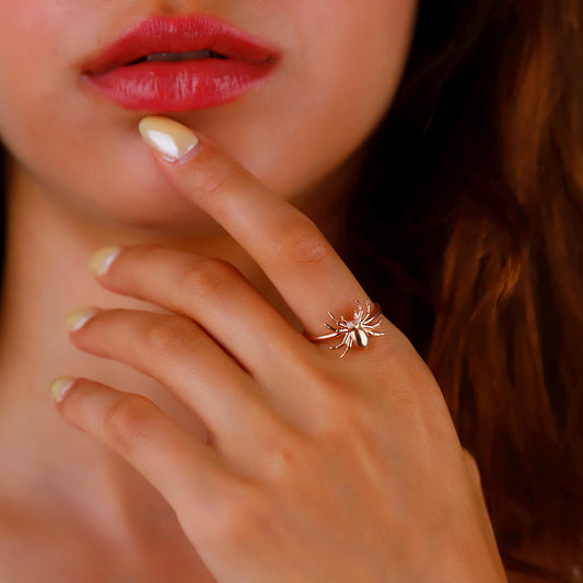 Close-up of a hand with a unique ring, near lips and hair.