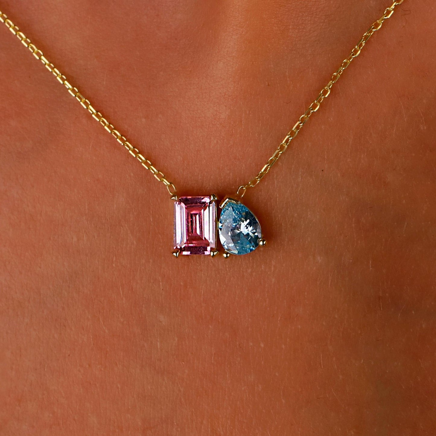Necklace with pink and blue gemstones on a skin background