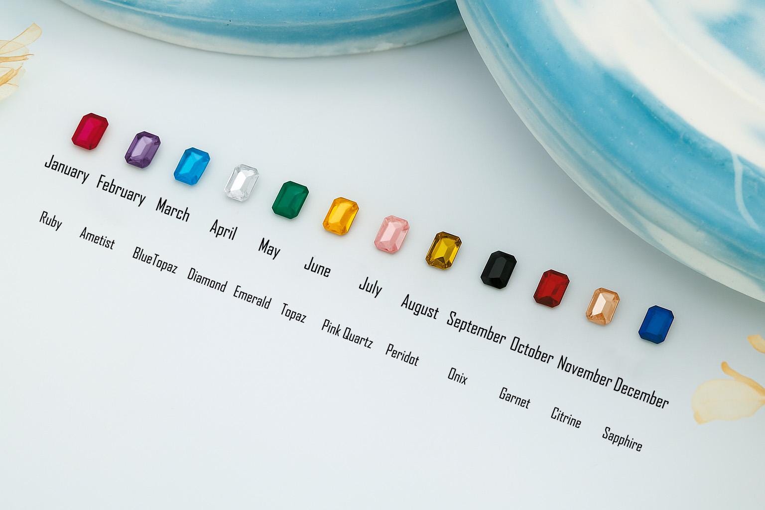 Colorful gemstones corresponding to months of the year on a white background