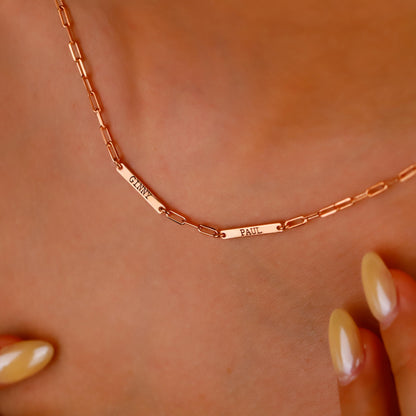 Rose gold necklace with engraved names on a person's neck