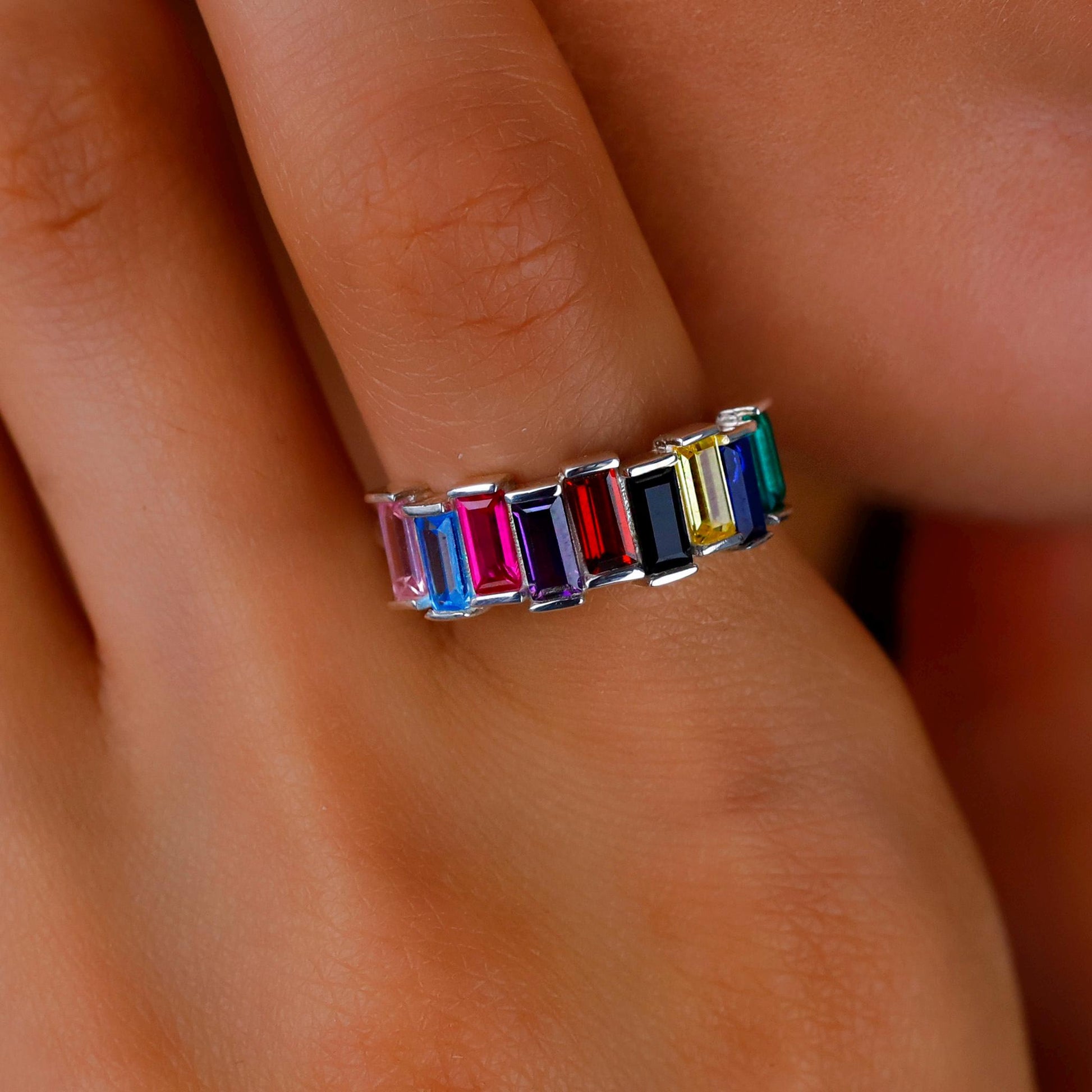 Multicolored gemstone ring on a finger