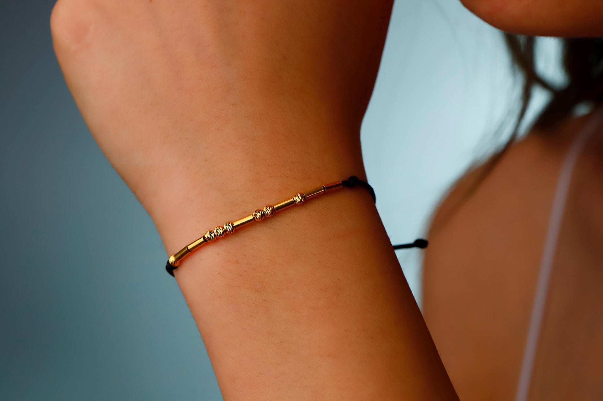 Gold bracelet on a wrist with a blurred background