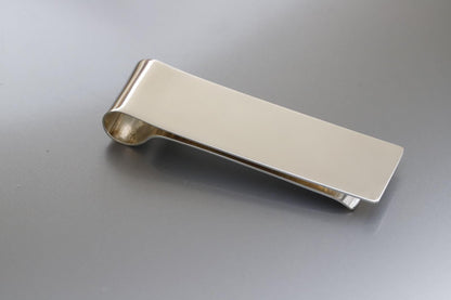 Silver money clip on a gray background