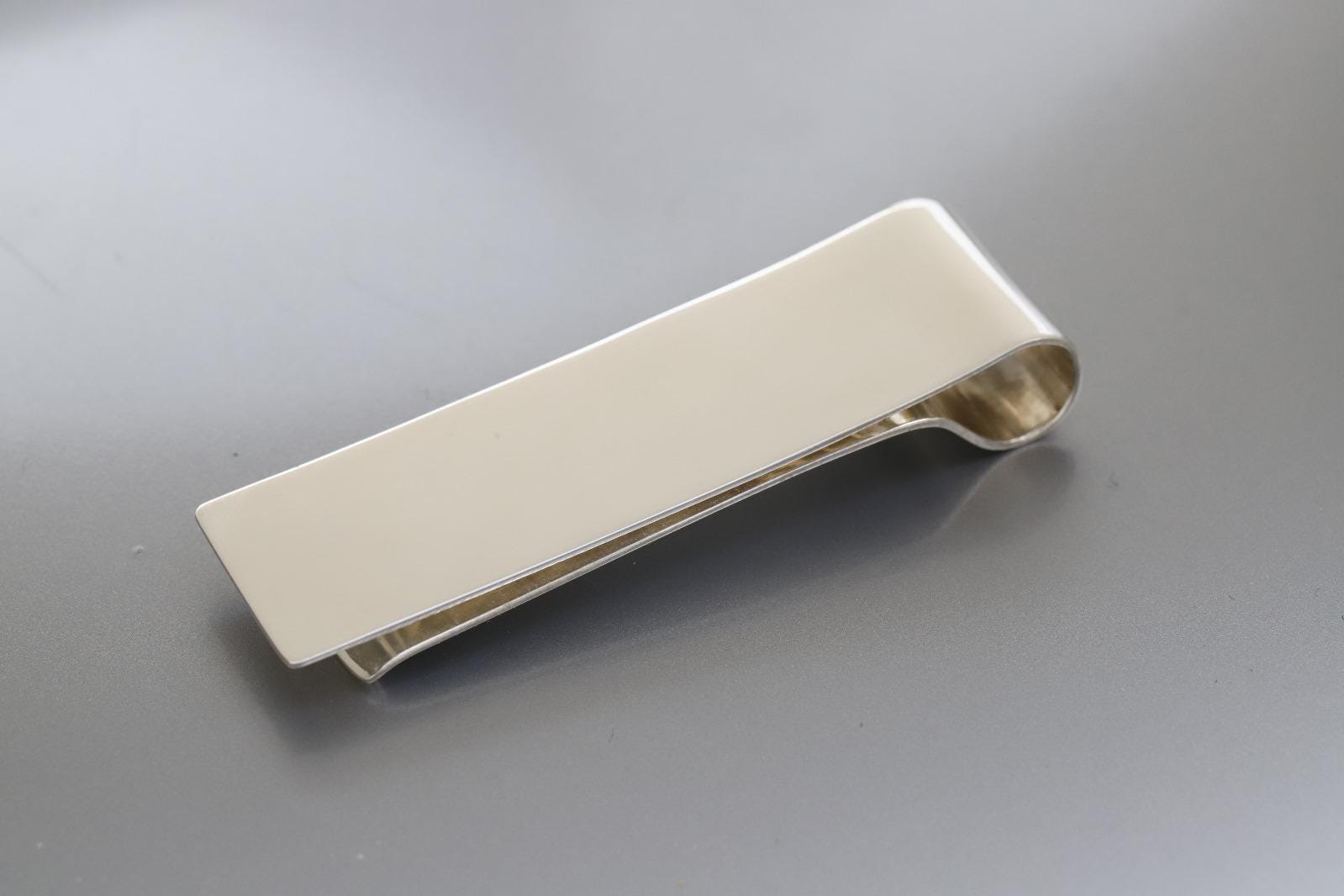Silver money clip on a gray background