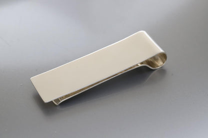 Silver money clip on a gray background
