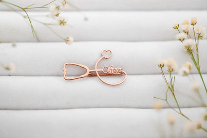 Rose gold name clip with 'Olivia' on a white background with delicate flowers