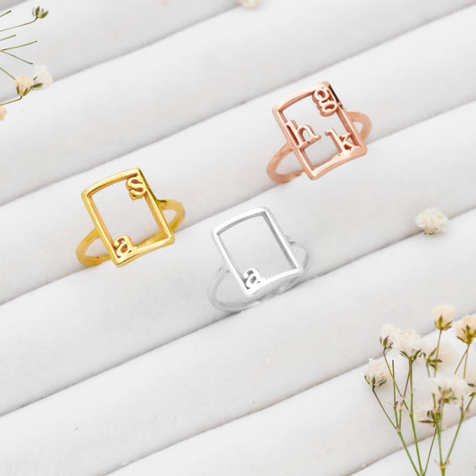 Three rings in gold, silver, and rose gold on a white surface with small flowers.