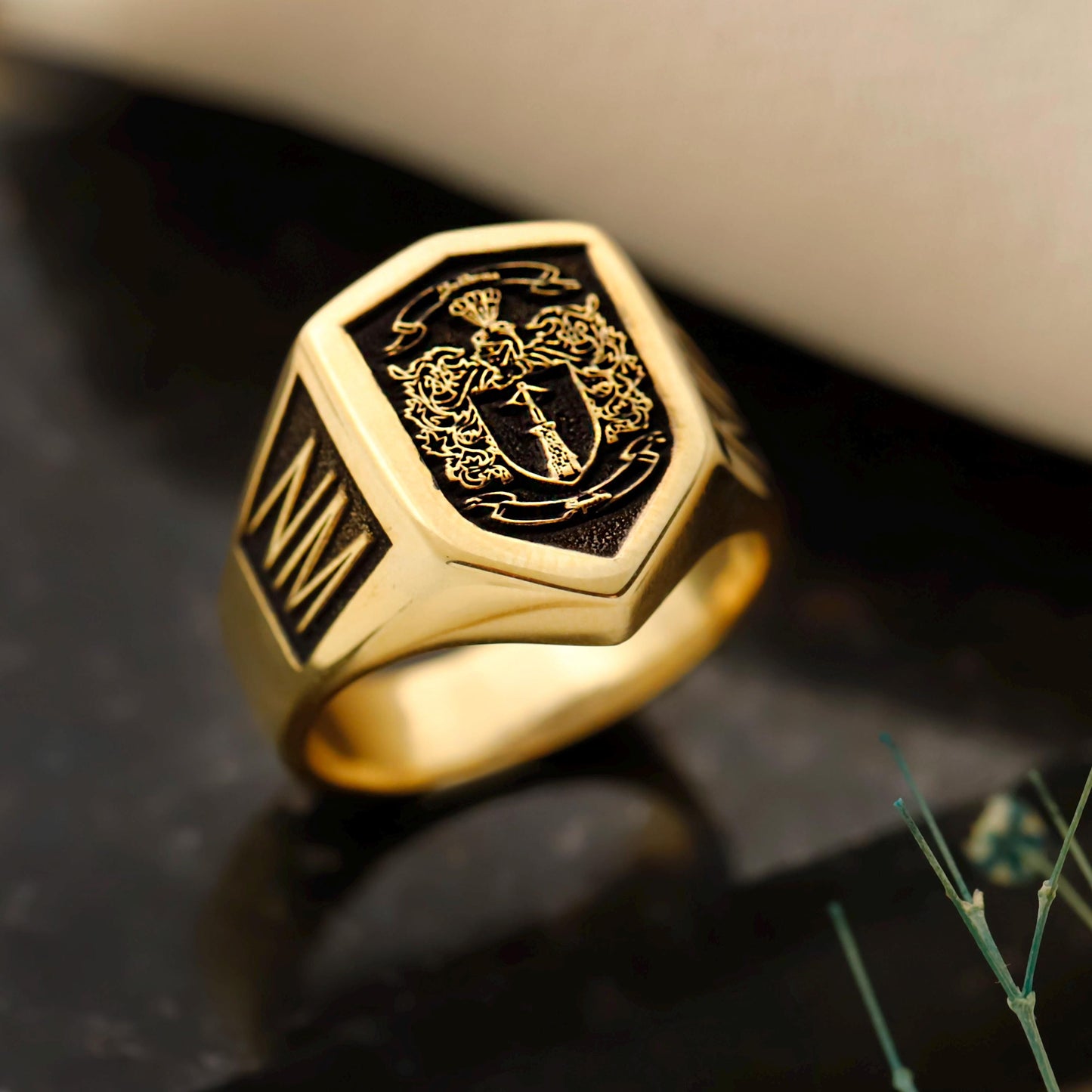 Gold ring with intricate design on a dark surface
